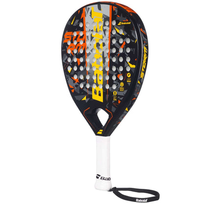 The Babolat Storm Padel Racket by Babolat features a black, yellow, and orange teardrop-shaped head, white handle, and wrist strap—perfect for beginner padel players.
