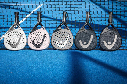 Five HEAD Speed Motion 2025 Padel Rackets by HEAD, each in a unique color, featuring Auxetic 2.0 technology, are lined up against a net on a bright blue padel court.