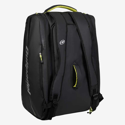 The Bullpadel BPP26022 XPLO Padel Racket Bag in black, inspired by Martín Di Nenno, features yellow-accented zippers and handle, multiple zippered compartments, padded shoulder straps, and a top handle. Brand: Bullpadel. Displayed on white background.