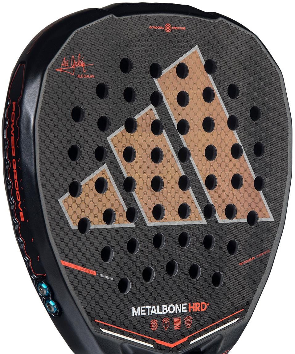 Close-up of the adidas Metalbone HRD+ by Ale Galán 2026 Padel Racket, showcasing a bold white logo, hexagonal pattern, round holes, orange accents, and a textured surface with visible adidas branding.