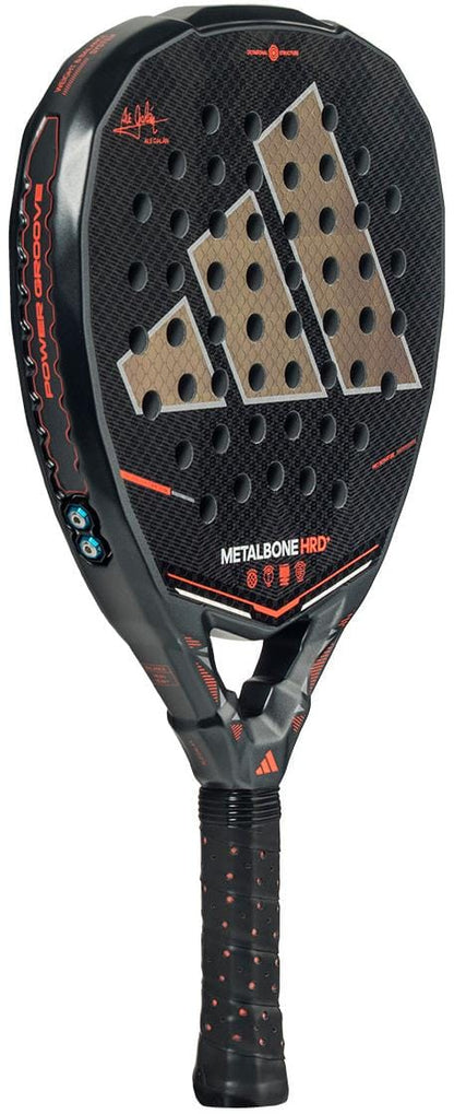 The adidas Metalbone HRD+ by Ale Galán 2026 Padel Racket features a black design with orange accents, hexagonal holes, "METALBONE HRD" near the bottom, the Adidas logo in the center, and a stylish black-orange handle wrap.