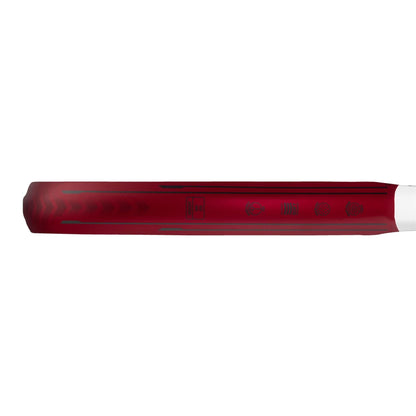 A close-up side view of a red handle, likely from the adidas ADIDAS Metalbone Team 3.3 Padel Racket, featuring faintly visible symbols and text along its surface.
