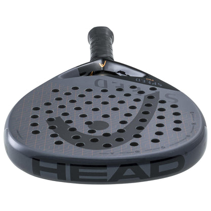 A close-up of the HEAD Speed Pro 2023 Padel Racket by HEAD highlights its orange accents, perforated surface, and textured grip handle for power and control, displayed from the front of the racket head.