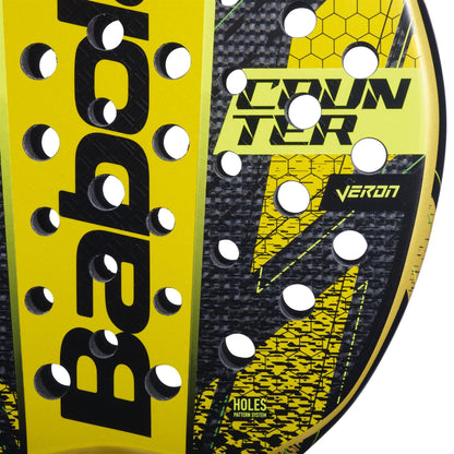 Close-up of the Babolat Counter Veron Padel Racket face in yellow and black, displaying "COUNTER," "VERON," "HOLES PATTERN SYSTEM," round holes, a honeycomb design, and advanced Carbon Flex technology.