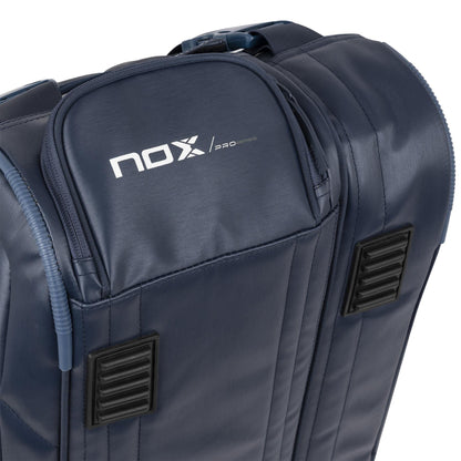 Close-up of the NOX Pro Series Padel Racket Bag - Blue, featuring a sturdy top handle, zippers, dual rectangular ventilation panels, and the NOX logo on the upper pocket. ThermoTech technology protects your gear.