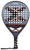 The NOX AT10 Genius Junior By Augustin Tapia 2025 Padel Racket features a carbon frame, black and gray design with a bold "X," circular holes, a black handle with the NOX logo, and wrist strap—ideal for young players' development.