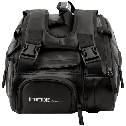 The NOX Pro Series Padel Racket Bag - Black features padded straps, an ergonomic handle, multiple zippers, side pockets, and the iconic NOX logo on the front pocket. It’s sturdy and ideal for carrying sports or travel gear.
