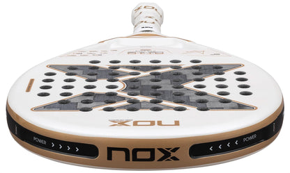 Close-up of the NOX AT10 Genius 12K Alum Extrem By Agustín Tapia 2026 padel racket, featuring a bold black "X" design with holes, gold accents, and "POWER" and "NOX" printed on the edge—Agustín Tapia's signature style.