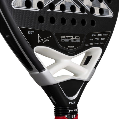 Close-up of the NOX Luxury AT10 Genius Attack 18K Alum By Agustin Tapia 2026 padel racket, displaying its 18K aluminised carbon surface, NOX branding, technical details, signature, and a vibrant red grip tape on the handle.