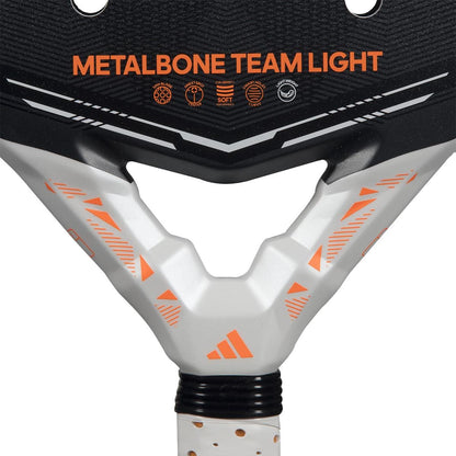 Close-up of the adidas Metalbone Team Light 2026 Padel Racket for advanced players, featuring black and white geometric designs, an adidas logo by the handle, and "METALBONE TEAM LIGHT" in bold orange text.