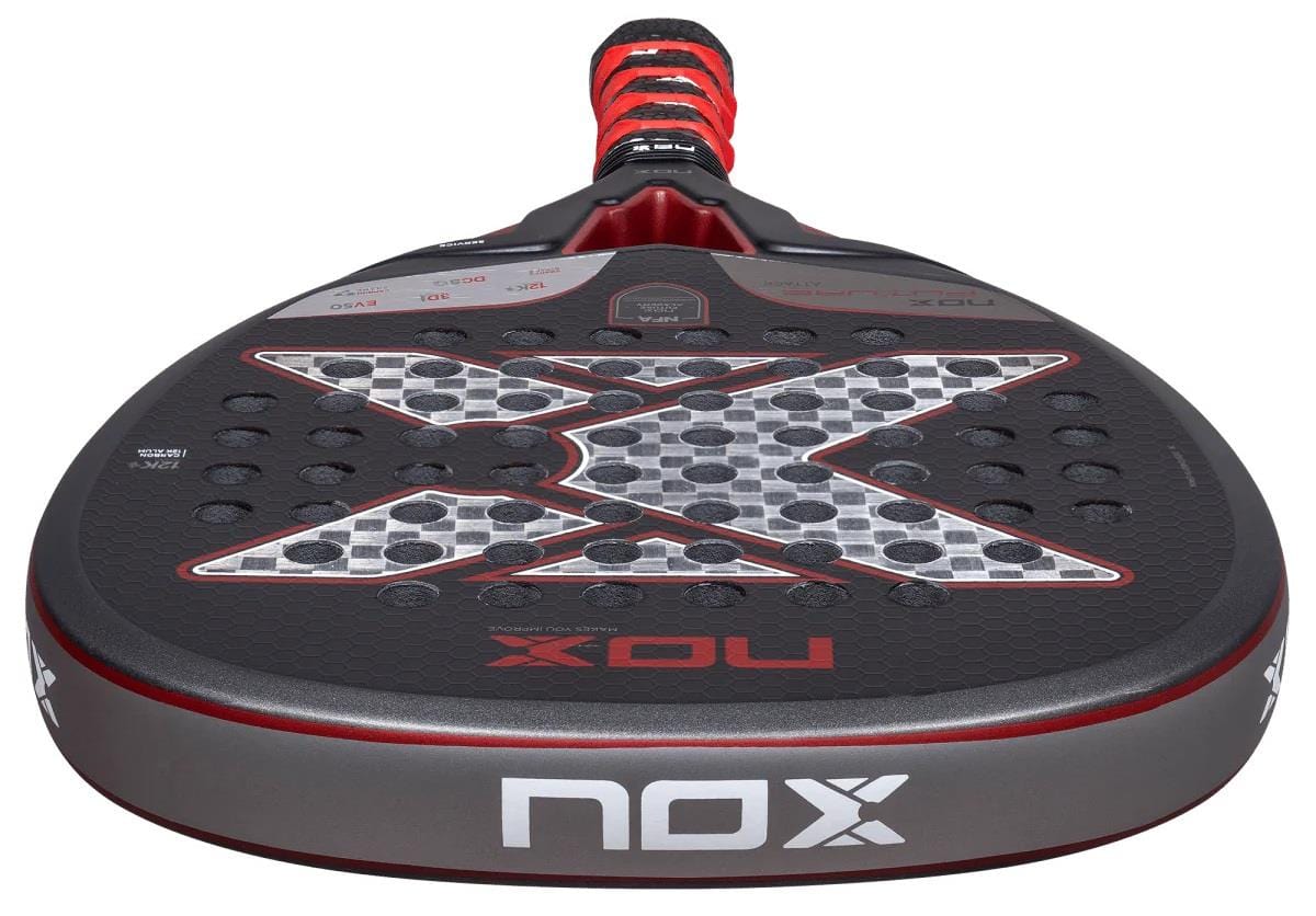A close-up of the NOX NFA Future Attack 12K Alum Padel Racket by NOX, showing its black and red handle, bold "X" design, and circular perforations on the face designed to enhance power.