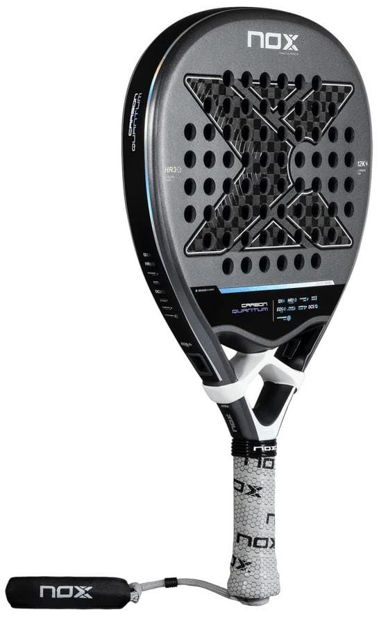 The NOX Luxury Quantum 12K Carbon 2025 Padel Racket features a black and silver design, X-shaped hole pattern, white grip with printed tape, 12K carbon fibre construction, and a black wrist strap.