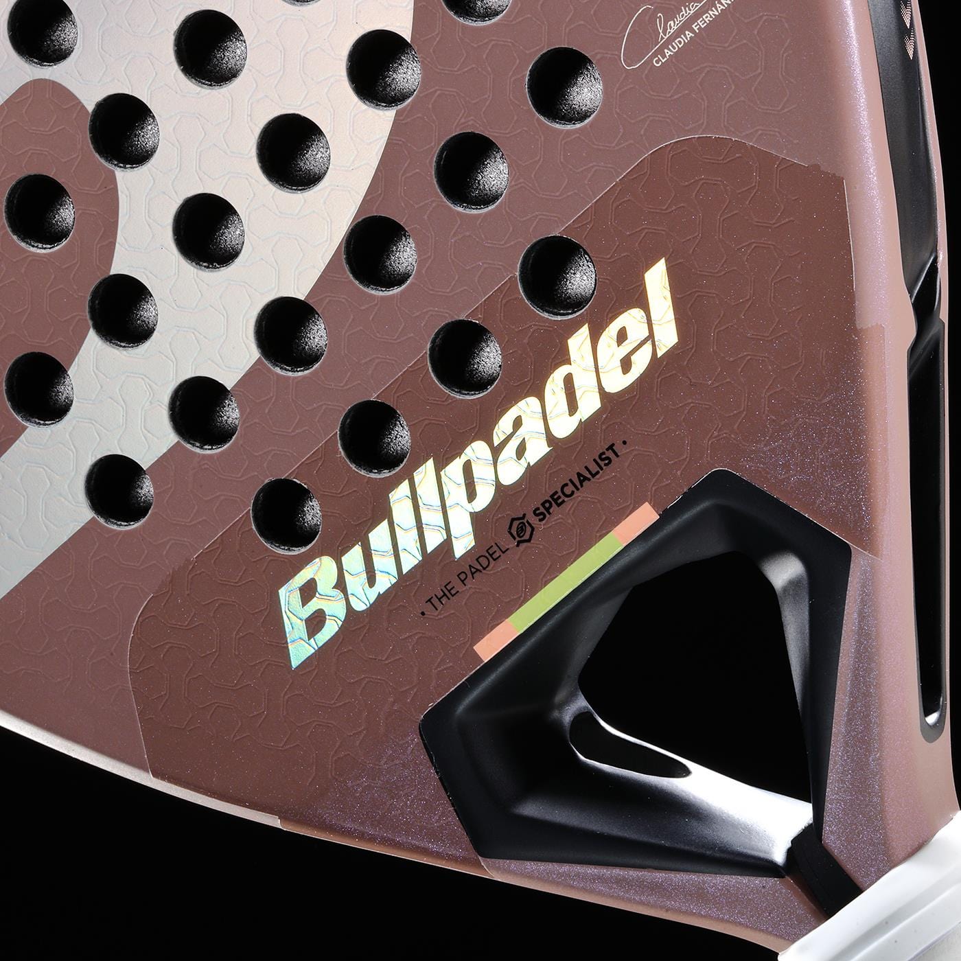 Close-up of the Bullpadel Wonder 2026 Padel Racket, showing the iridescent Bullpadel logo, a Hyper Core textured surface with holes, geometric design elements, a hint of tricolor detail, and part of the grip area.
