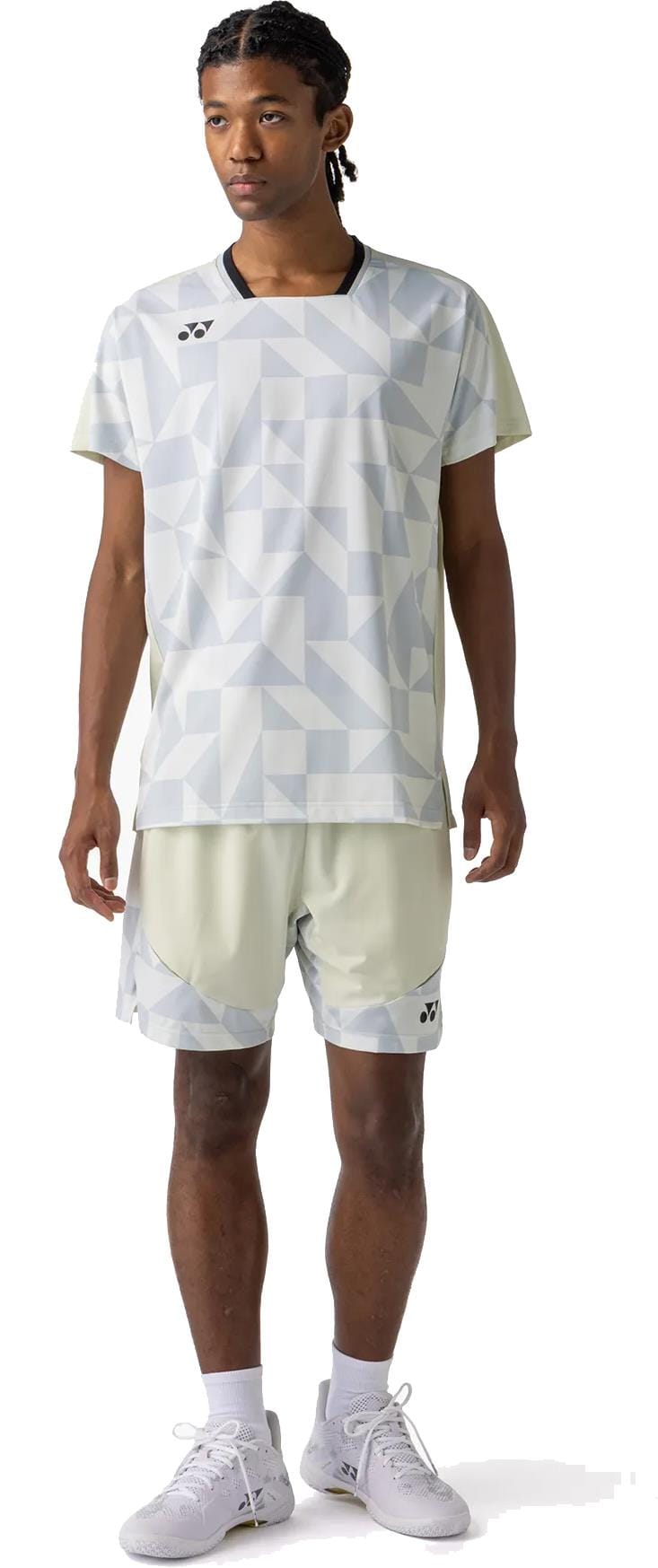 A person faces forward wearing Yonex 15240YX Knit Men's Padel Shorts in Champagne, styled with a light geometric T-shirt, white athletic shoes, and socks, against a plain white background.