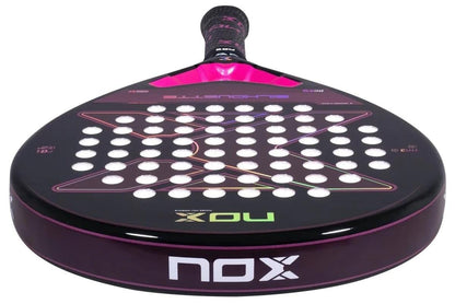 A close-up of the NOX X-One Silhouette Advance Series Padel Racket, featuring a black and pink design with white holes and the "NOX" logo—perfect for beginner and intermediate players.