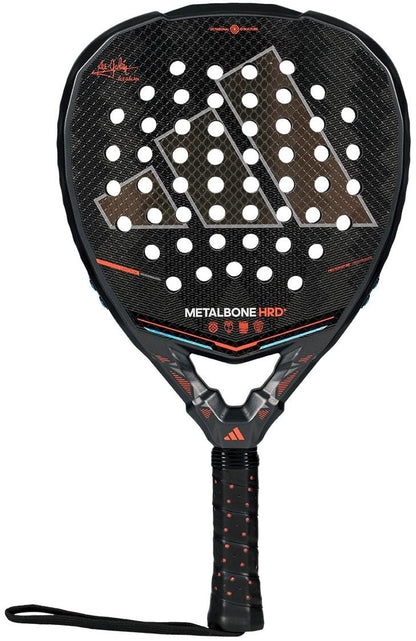 The adidas ADIDAS Metalbone HRD+ by Ale Galán 2026 Padel Racket features a black design, honeycomb pattern, circular holes, red and white accents, and a wrapped handle with wrist strap—ideal as a power racket for advanced players.