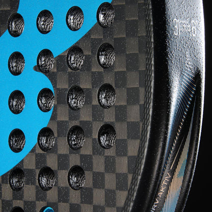 Close-up of the Bullpadel Vertex 05 Hybrid 2026 Padel Racket by Bullpadel, featuring a carbon fiber texture, hybrid shape, perforated holes, blue graphics, metallic accents, and small white text along the edge.