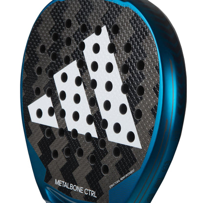 Close-up of the adidas Metalbone CTRL 3.3 padel racket for advanced players, showing a large white geometric logo and multiple round holes on the surface. “Metalbone CTRL” text is visible at the bottom.
