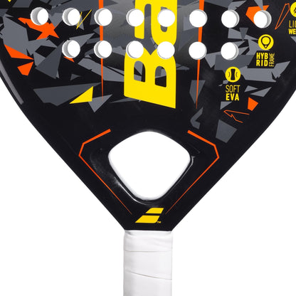 Close-up of the Babolat Storm Padel Racket by Babolat, showcasing a teardrop shape, geometric patterns, yellow and orange accents, white perforated holes, a white grip handle, and text reading "SOFT EVA" and "HYBRID FRAME.