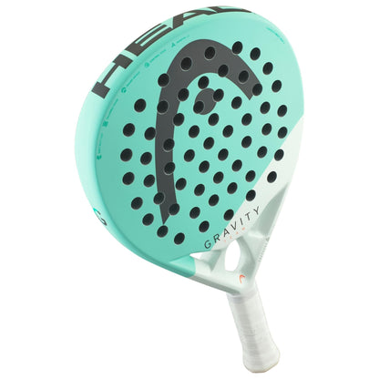The HEAD Gravity Team 2024 Padel Racket by HEAD features a light blue and white design, bold black logo, multiple holes, and Auxetic 2.0 technology—ideal for intermediate players seeking control and power.