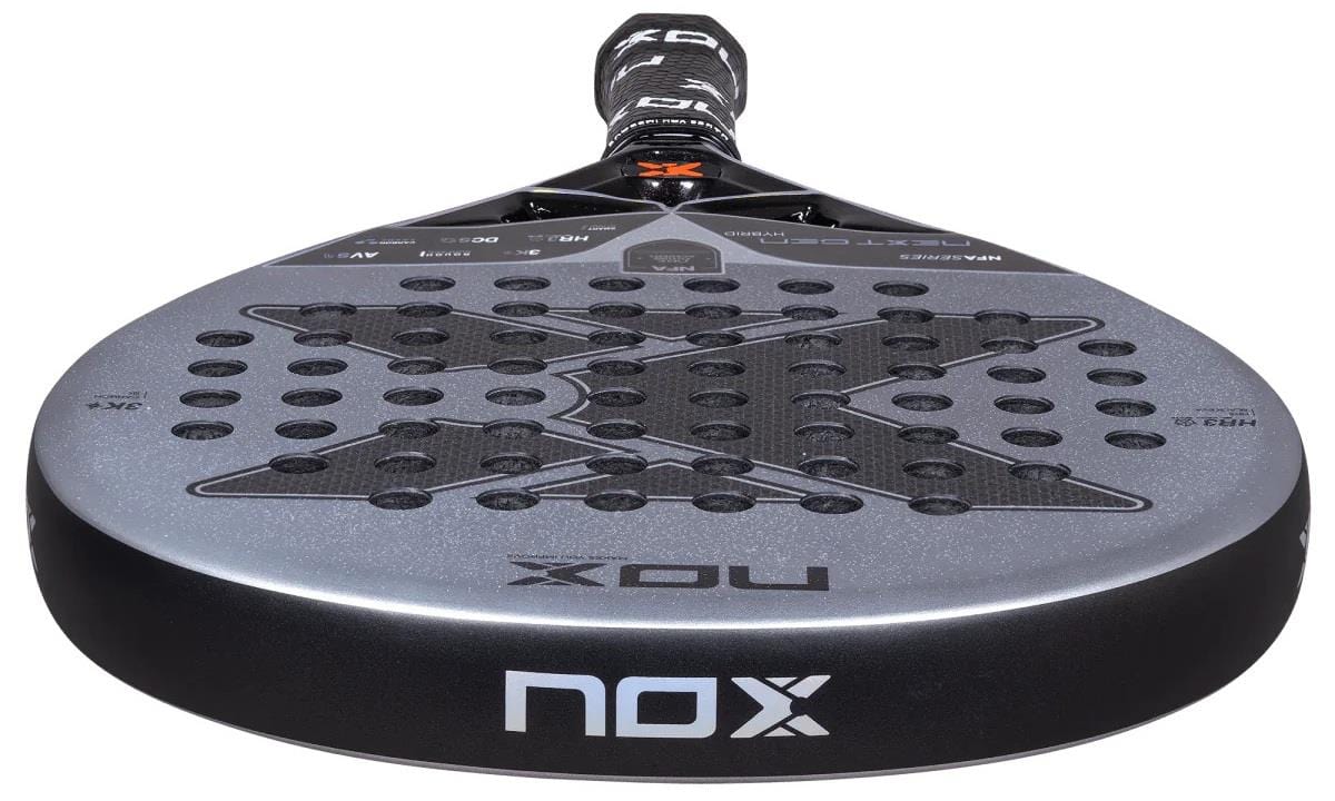A close-up of the NOX NFA Nextgen Pro Hybrid 3K Padel Racket shows its black and silver 3K carbon surface with a large X design, circular perforations, and the NOX logo on both the edge and handle.