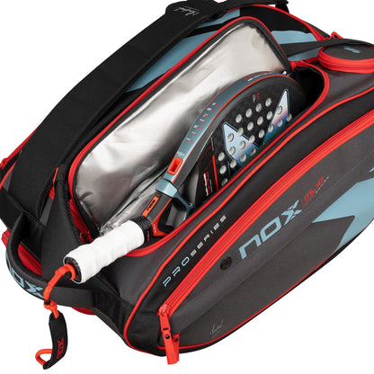 A partially unzipped NOX ML10 Team Padel Racket Bag - Black / Clay reveals a padel racket with a white grip and blue details inside. The black and gray bag features red accents and “Nox” branding from the Pro Series.
