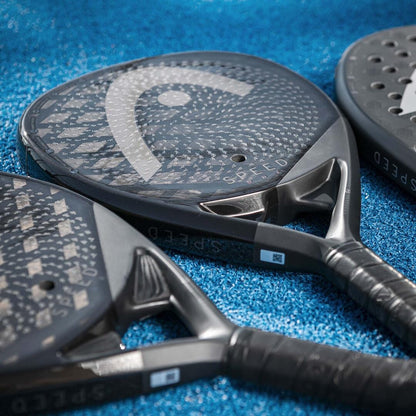 Close-up of three HEAD Speed One 2025 Padel Rackets with textured surfaces and HEAD branding, designed for power and control, resting on a blue textured court.