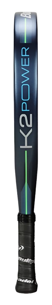 A close-up side view of the Bullpadel K2 Power 2025 Padel Racket in dark blue, featuring "K2 POWER" branding, a green stripe, and a black handle with textured grip for enhanced power and control.