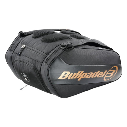 The Bullpadel Vertex 25 Padel Racket Bag in black features zippered compartments, a ventilated section, and a gold logo. It has top handles and ample space for gear like the Vertex Padel Racket.
