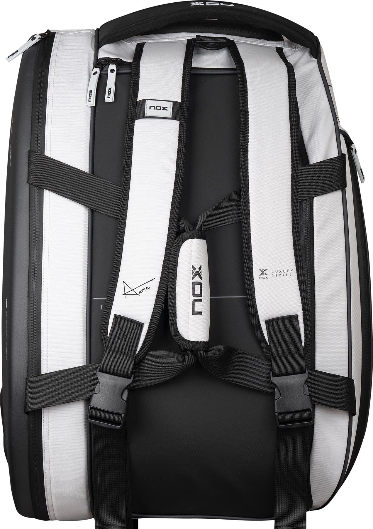 The NOX Luxury Master Series Padel Racket Bag in black and white features padded shoulder straps, black buckles, zipper compartments, and "NOX" branding on the bag and straps. Inspired by Miguel Lamperti, it is shown from the back.