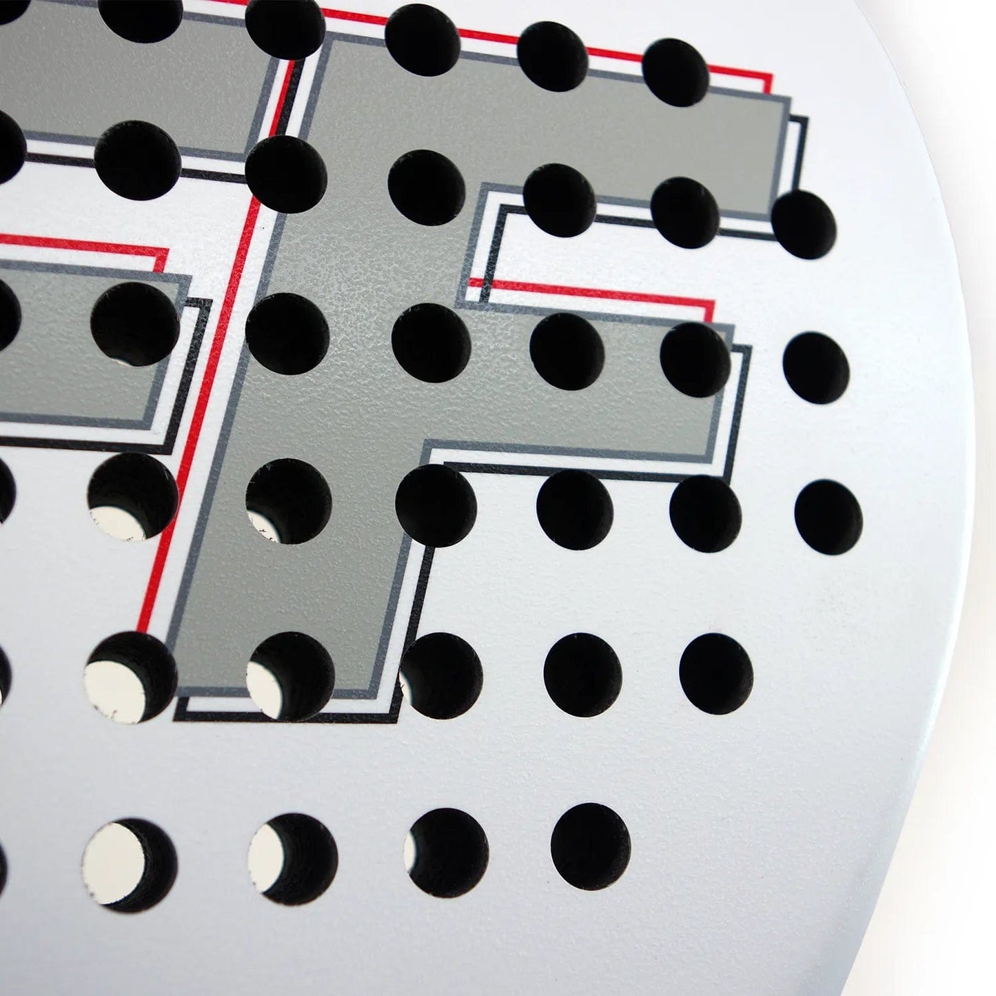 Close-up of the Karakal FF 365 Padel Racket by Karakal, featuring a white surface with black round holes in a grid for enhanced spin and control. A stylized gray letter "F" with red and black outlines appears in the background.