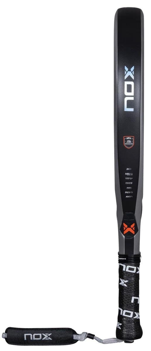 The NOX NFA Nextgen Pro Hybrid 3K Padel Racket is black with a white and orange logo, features a carbon 3K textured surface, and has a wrapped handle with NOX branding plus an attached wrist strap.