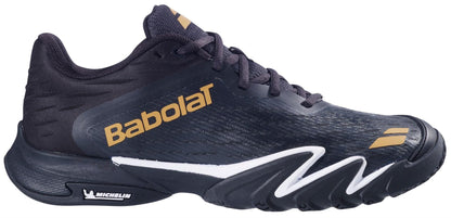 The Babolat Premura 3 Men's Padel Shoes in Black/Gold feature gold branding, a textured upper, white midsole details, and a Michelin outsole logo. Wavy sculpted side accents add a dynamic touch to the stylish design.