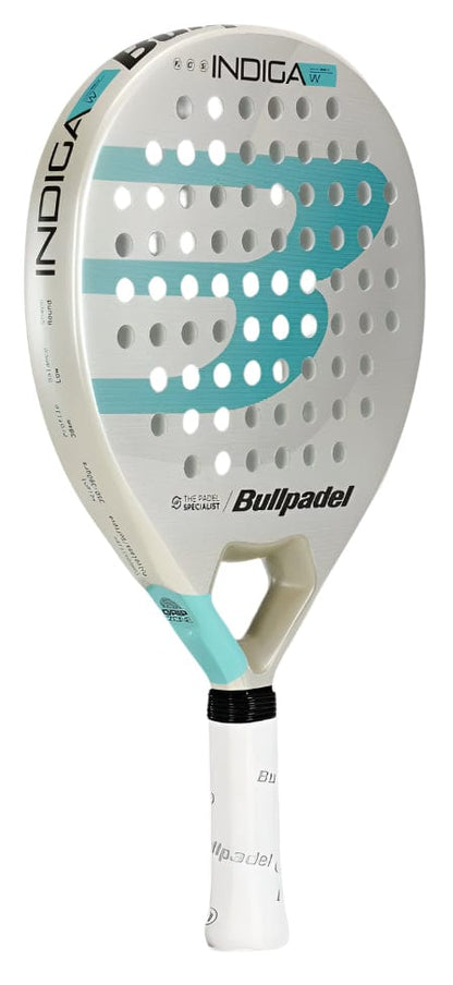 The Bullpadel Indiga W 2025 is a women's padel racket in white and turquoise, featuring "INDIGA W" on the top edge, a bold turquoise “B” logo on the face, and a white grip tape on the handle.