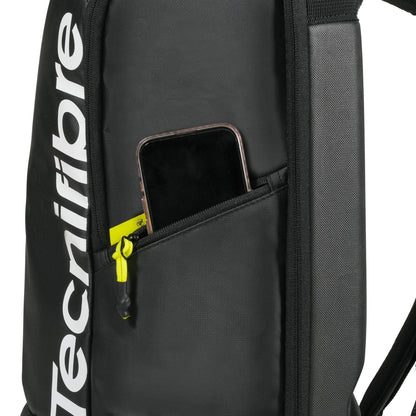 A close-up of the black Tecnifibre Reform Padel Backpack shows a partially unzipped side pocket with a smartphone inside and a yellow zipper pull, highlighting this Tecnifibre backpack’s sleek design and durable EVA material.