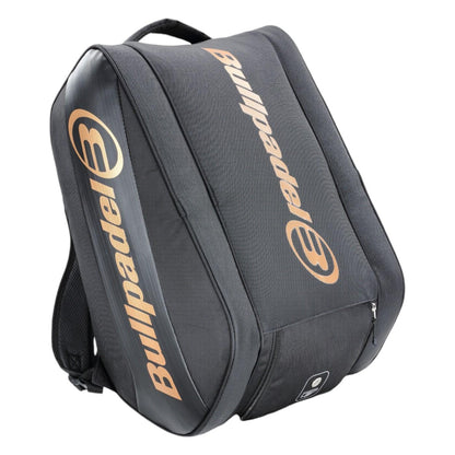 The Bullpadel Vertex 25 Padel Racket Bag in black boasts a gold logo, ventilated compartment for freshness, large central section, adjustable shoulder straps, and a front zip pocket—ideal for technical racket storage or casual use.