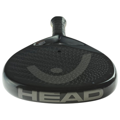 A close-up of the black HEAD Speed One X 2025 Padel Racket shows "HEAD" in large silver letters on the frame, a subtle circular face pattern, and advanced Auxetic 2.0 technology for superior performance.