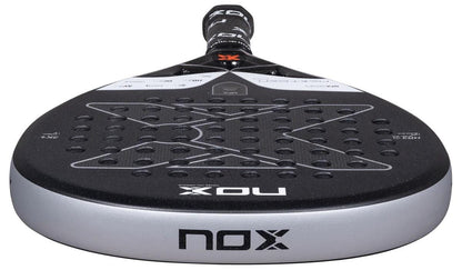 Close-up of the NOX NFA Nextgen Pro Attack 3K Padel Racket by NOX, featuring its perforated surface and visible brand logos on both the base and top of the handle.