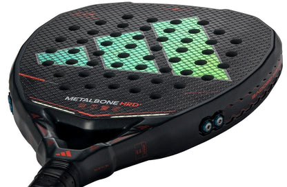 Close-up of the adidas Metalbone HRD+ by Ale Galán 2026 Padel Racket, a power racket with a hexagonal texture, green and blue geometric design, red "METALBONE HRD" lettering, multiple holes, and red details.
