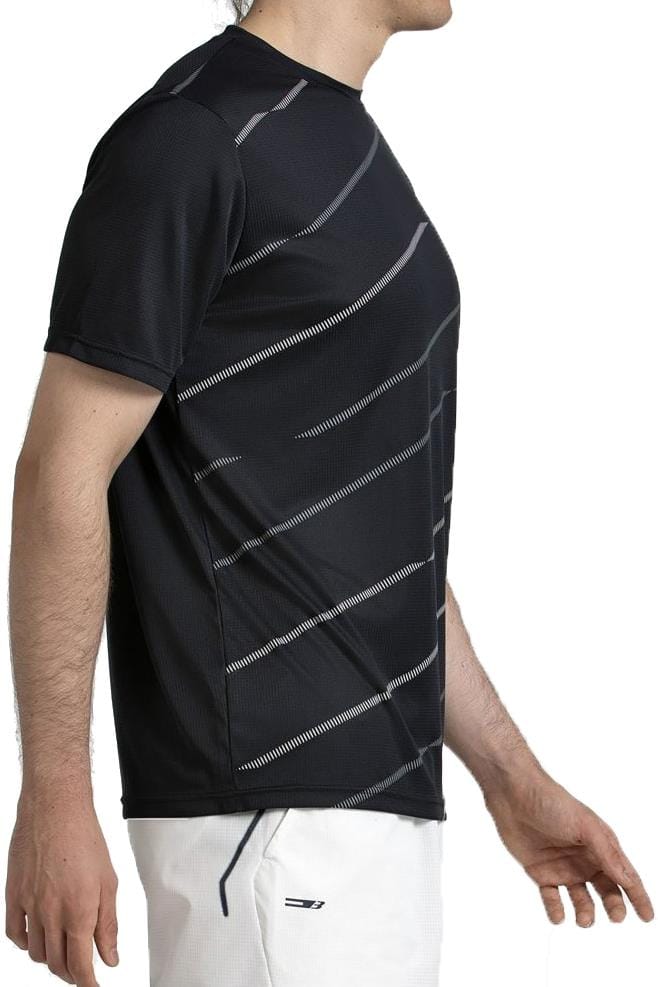A man stands in profile against a white background, wearing the Bullpadel Casinas Mens Padel T-Shirt in black with diagonal white stripes and lightweight polyester fabric featuring Quickerdry technology, paired with white shorts.