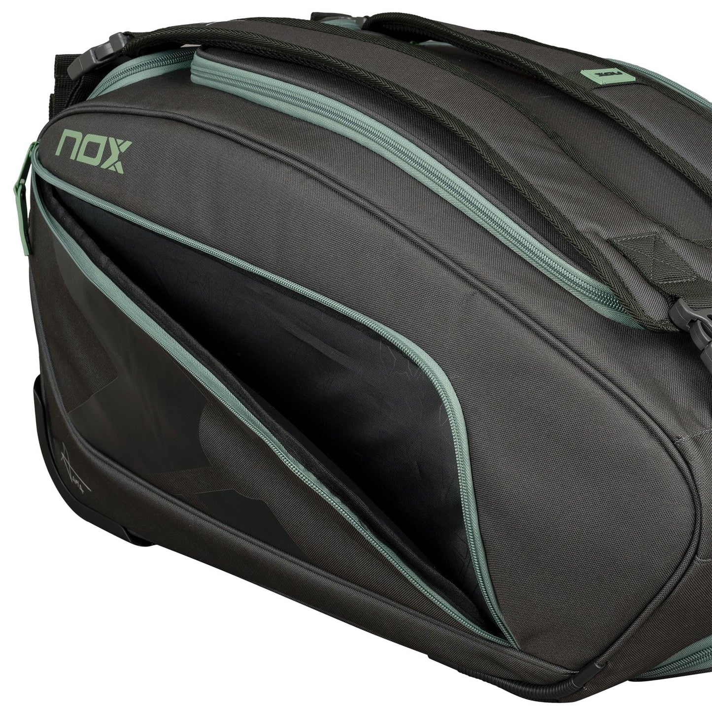 A close-up of the NOX AT10 Competition Trolley Padel Racket Bag - Black / Green by NOX, featuring green zippers and one partially open compartment. This wheeled padel bag offers smooth, durable fabric and a sturdy build.