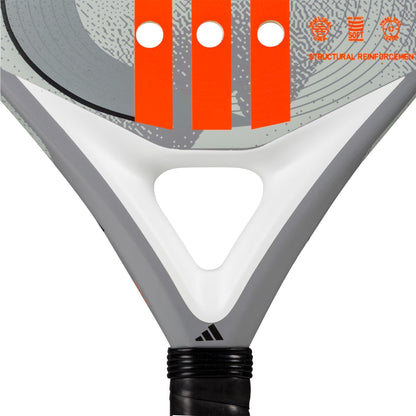 Close-up of the adidas Drive Grey 3.4 Padel Racket, showing its gray, white, and orange design with orange stripes, three holes, black grip, icons, and "STRUCTURAL REINFORCEMENT" text in the corner.