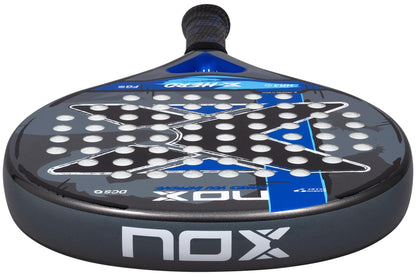 Close-up of the NOX X-Hero Blue Padel Racket by NOX, featuring a stylish black and blue design with a bold center "X," white holes, and grip-wrapped handle—perfect for beginners seeking control and precision.