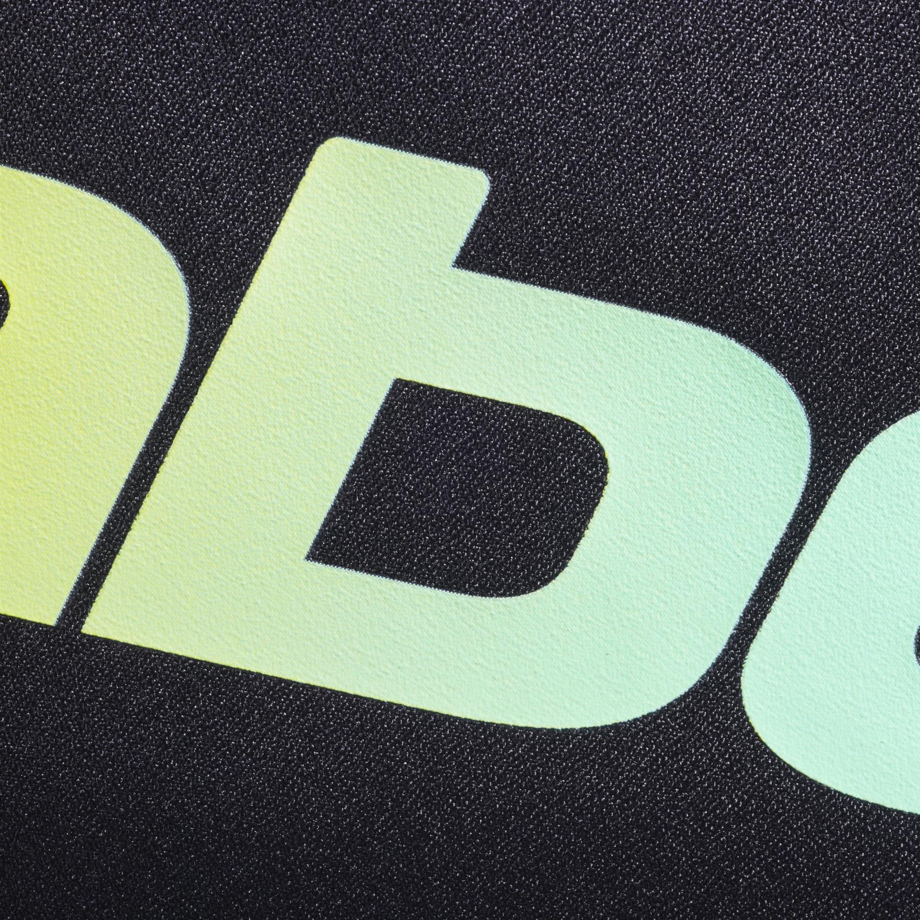 Close-up of lowercase yellow-green gradient letters "ab" on textured black evokes the modern, bold style of the Babolat Court S Padel Racket Bag - Black / Multi by Babolat, made from recycled polyester.