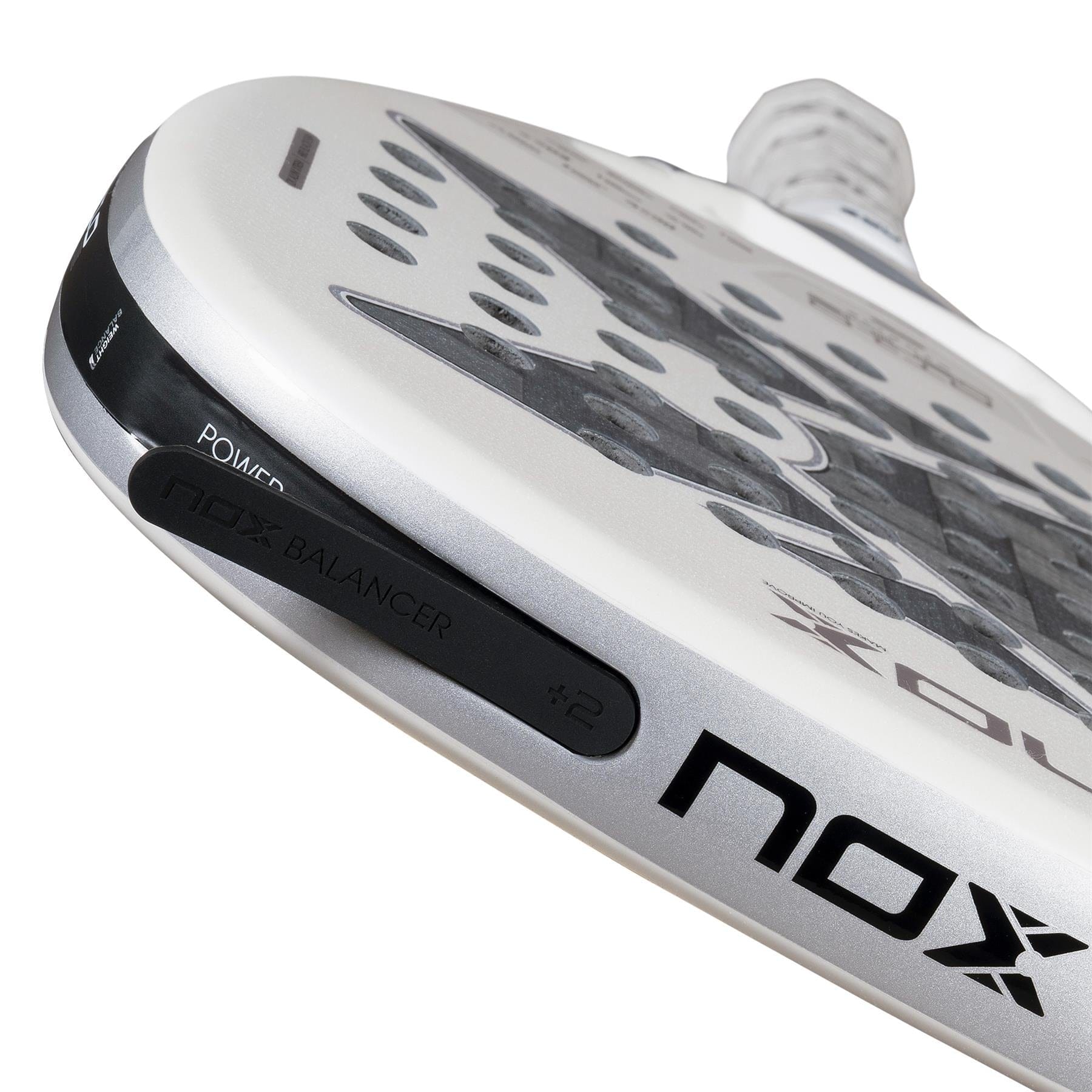 Close-up of the NOX AT10 Genius Attack 12K Alum Extrem By Agustín Tapia 2026 padel racket, showing "NOX BALANCER +2," "POWER," and the NOX brand. The sleek white-silver design reflects its focus on precision and power for enthusiasts.