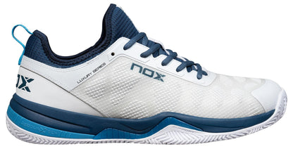 The NOX Nerbo Mens Padel Shoes in White/Swedish Blue feature a mesh upper, blue sole and accents, blue laces, heel pull tab, and "NOX" plus "LUXURY SERIES" text for comfort and performance on court.