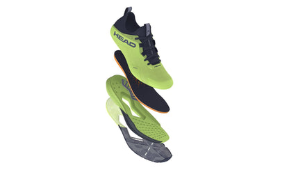 Exploded view of the HEAD Motion Pro Mens Padel Shoes in lime and navy features separated layers: outer sole, midsole, insole, and upper for breathability insights. Branding appears on the side against a white background.