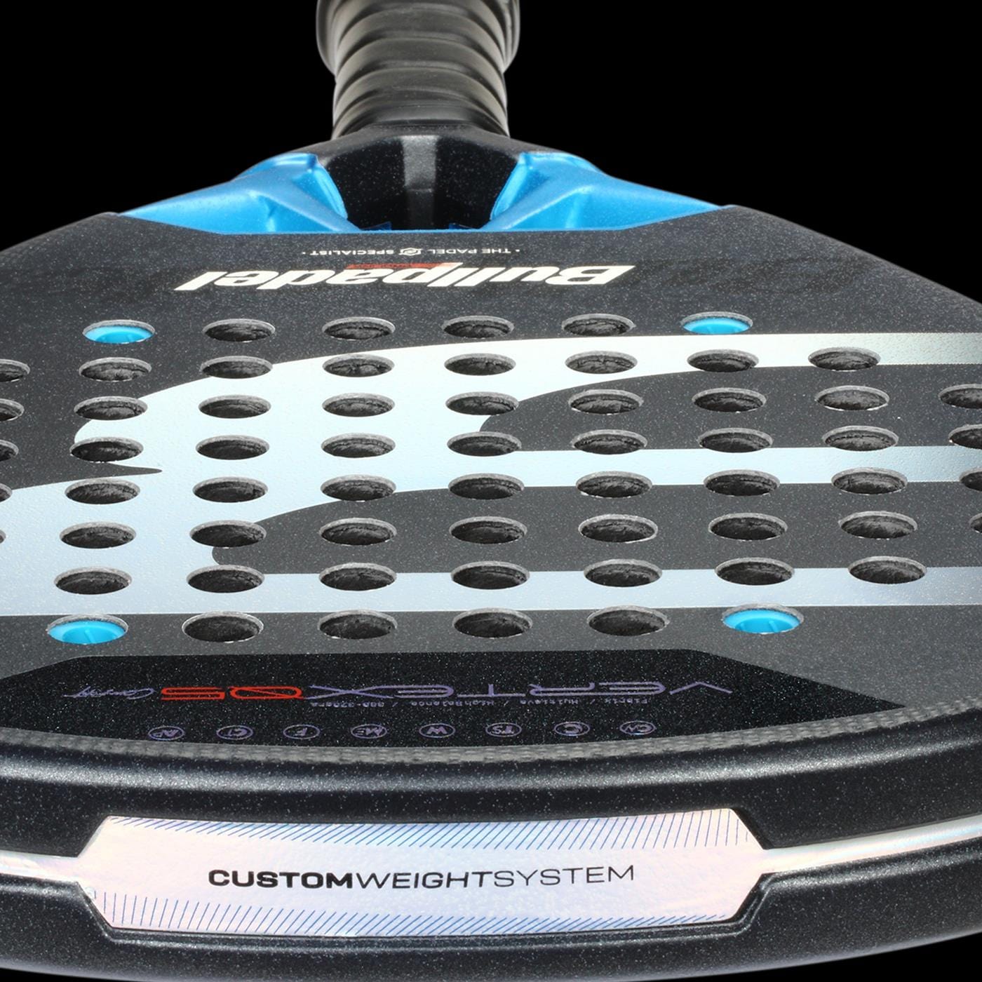 Close-up of the Bullpadel Vertex 05 Comfort 2026 Padel Racket featuring a black, blue, and silver design. Visible text includes "Bullpadel," "Vertex 05," and "CUSTOM WEIGHT SYSTEM." It has round perforations on the surface.