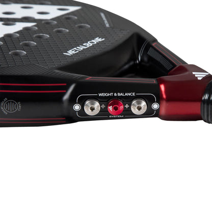 Close-up of the adidas Metalbone 3.3 Padel Racket, featuring a "Weight & Balance" system with two metal screws and a red dial by the handle for tailored play.