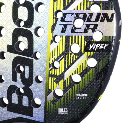 Close-up of the Babolat Counter Viper 2.5 Padel Racket, featuring a textured surface, circular holes, and "COUNTER VIPER," "VIBRASORB SYSTEM," and "HOLES PATTERN SYSTEM" text on a yellow, black, and silver design by Babolat.